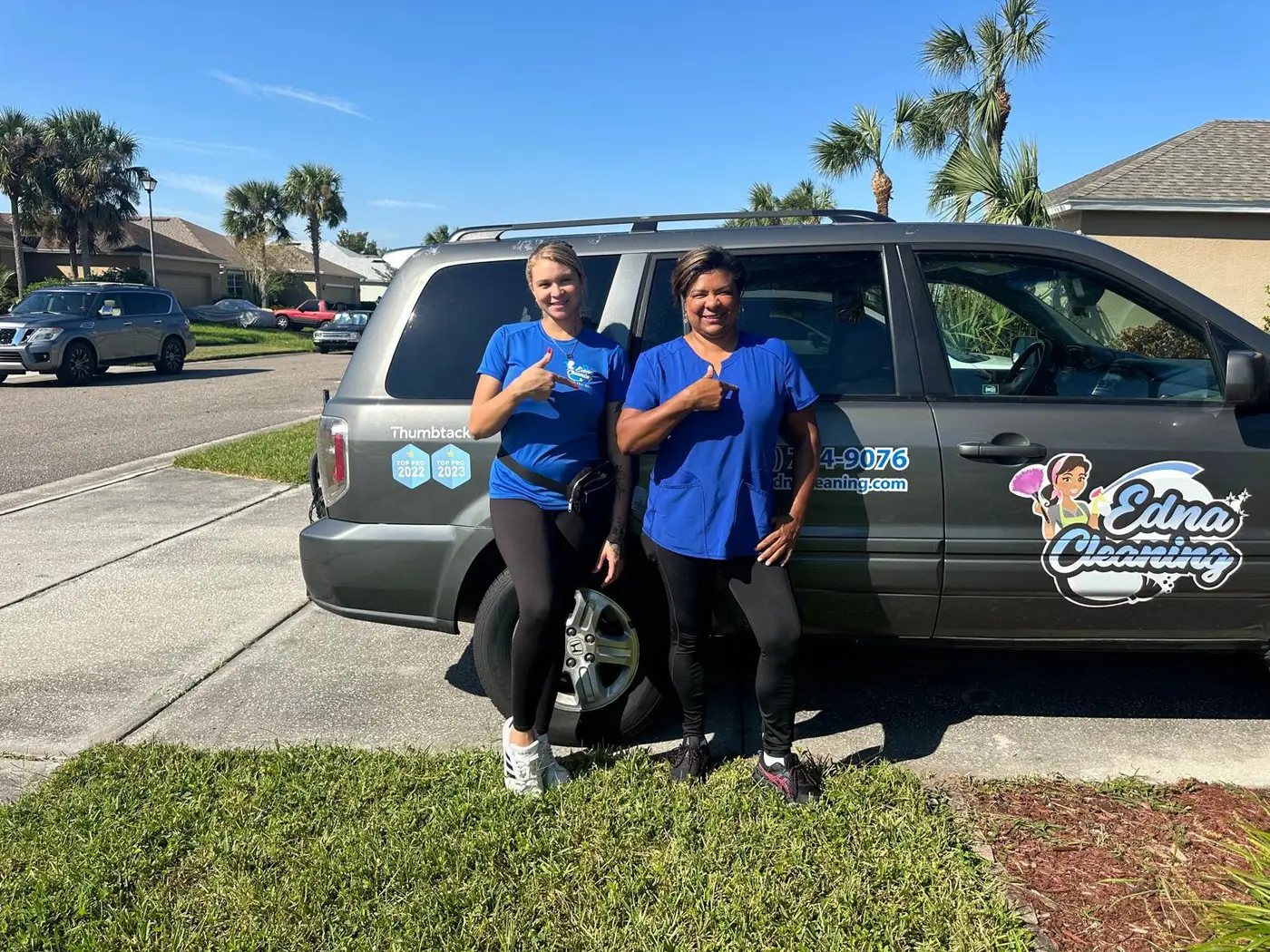 Two Edna Cleaning team members beside the company's branded van